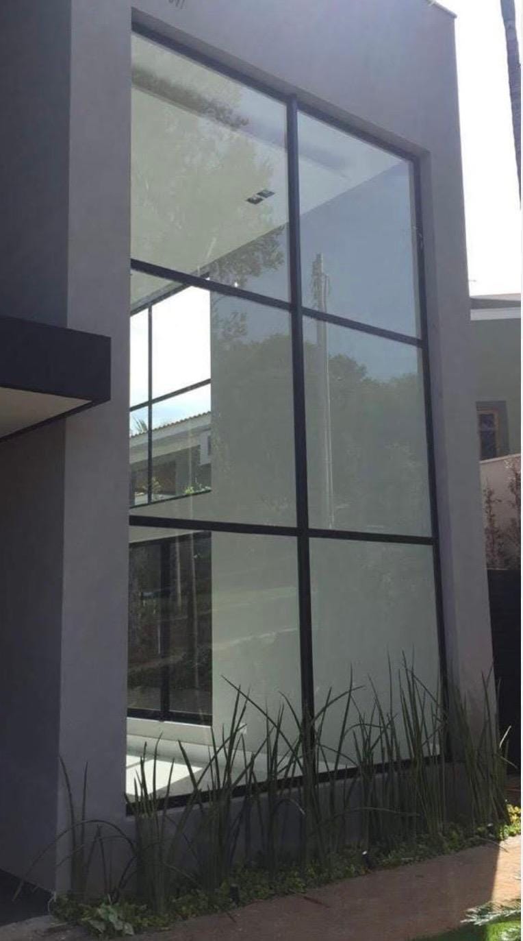 Fachada de vidro com estrutura preta, obra da Temper RJ Vidros no Rio de Janeiro RJ